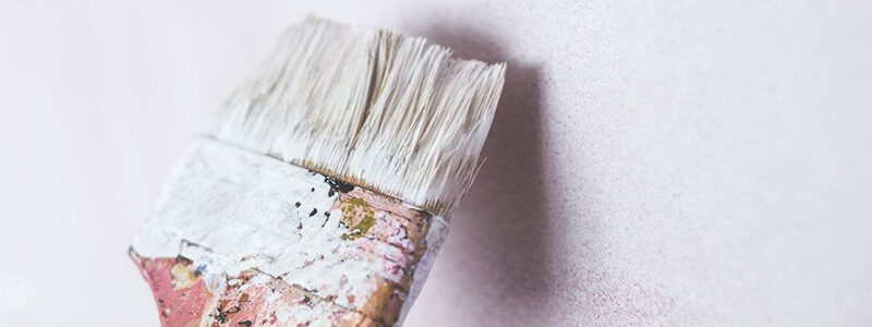 Paint brush painting a wall.