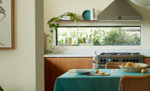 Kitchen window with a kitchen table setting with some fruit.