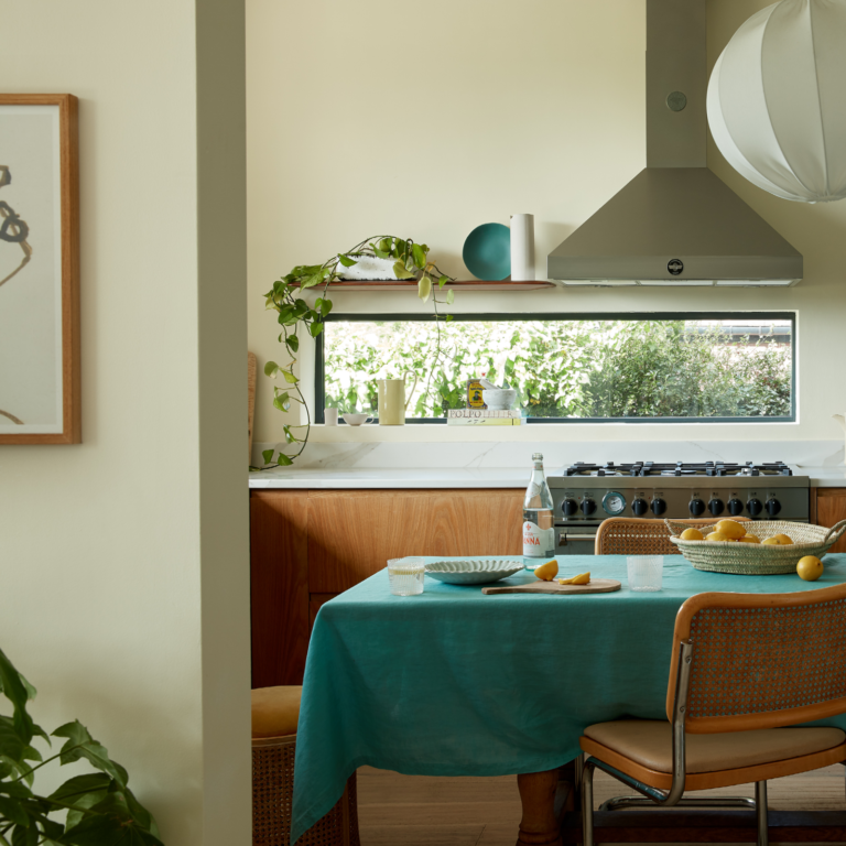 Kitchen window with a kitchen table setting with some fruit.