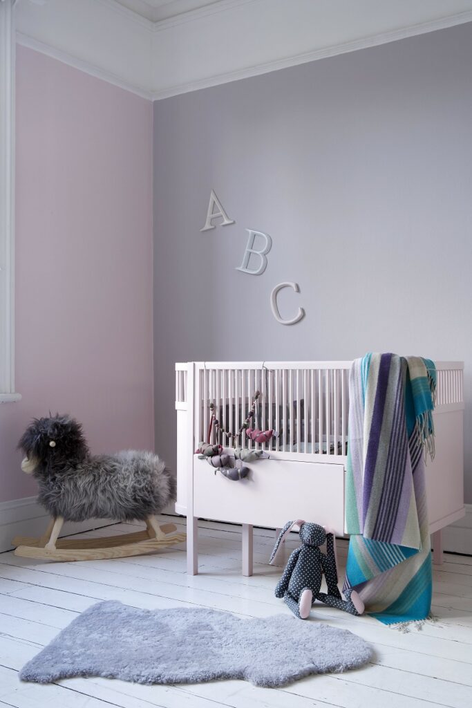 Nursery walls painted in Rosie Posie and Inglenook with cot in Cupcake