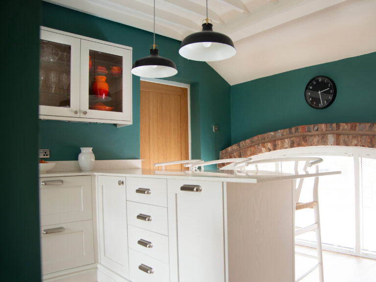 Kitchen in a cottage with a lovely raw brick arch above the window.