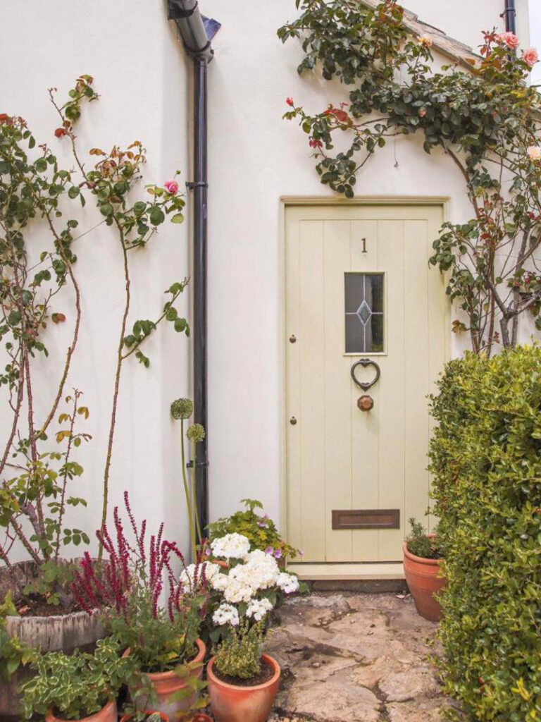 A stone path leading up to a cottage door in a court yard.