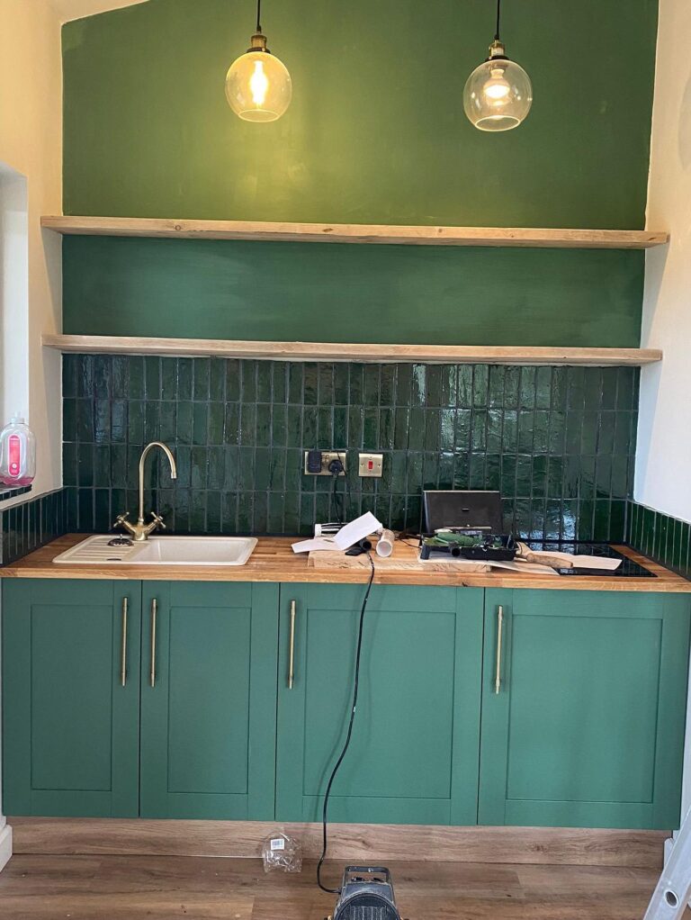 Progress photo of the renovation of a green kitchen.