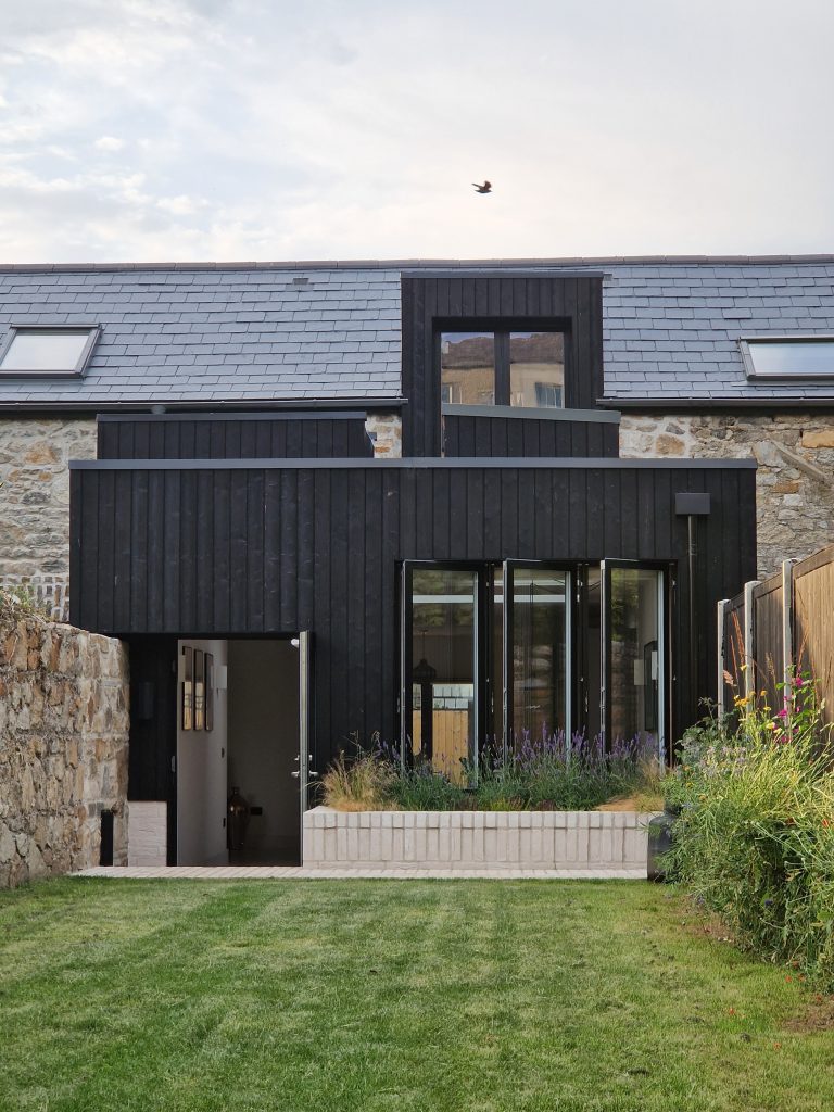 Bray coach house with green lawn.
