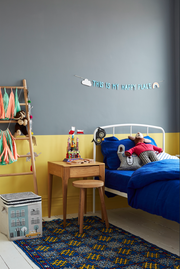 Childs bedroom with walls painted in yellow and grey paint